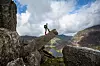 Hiker looking at the view of the Ogwen Valley from Cannon rock on Tryfan, Snowdonia (Eryri), Wales.