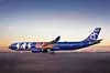 Ett blått SAS-flygplan står på en landningsbana vid soluppgång.