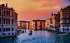 En kanal i Venedig med båtar mellan gamla byggnader i kvällsljus.