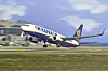 Ett Ryanair-flygplan lyfter från en flygplats med blå himmel i bakgrunden.