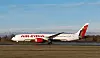 Ett Air India-passagerarplan står på en flygplatsbana under klar himmel.