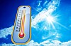 En termometer mot blå himmel och solsken som visar hög temperatur.