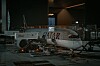 Ett passagerarplan från Qatar Airways står parkerat vid en gate i en upplyst flygplatsterminal.