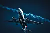 Ett Delta Air Lines-flygplan ses underifrån mot mörk himmel med kondensstrimma bakom.