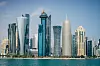 Modern stadsprofil med höga skyskrapor vid havet under blå himmel. West Bay, Doha, Qatar.
