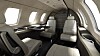 Interiör i privatjet med vita lädersäten och stora fönster längs kabinens sida.