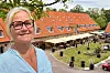 Lise-Lott Modin framför Hotel 1622 med uteservering och röda tak i Rydebäck.