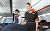 Två kabinanställda står i gången i ett easyJet-plan med passagerarsäten runt omkring.