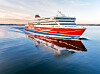 Ett rödvitt Viking Line-fartyg går på stilla vatten och speglas i havsytan.