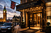 Belyst hotellentré med texten Luxury Hotel London, brittisk flagga och Big Ben i bakgrunden.