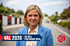 Kvinna i blå kavaj står på en väg med valgrafik och Socialdemokraternas logotyp.