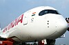 Närbild av nosen på ett vitt Air India-flygplan med bolagets logotyp och Indiens flagga.