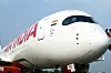 Närbild av nosen på ett vitt Air India-flygplan med bolagets logotyp och Indiens flagga.