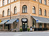 Ljus stenfasad med skylten Hotel Ruth, markiser, entré och uteservering längs en stadsgata.