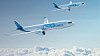 Två blåvita passagerarflygplan flyger över ett molntäcke under en klarblå himmel.