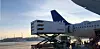 Ett SAS-flygplan står vid en flygplats medan en Newrest-lastbil lastar ombord catering.