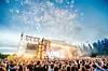 Stor publik framför en upplyst utomhusscen med texten ”LOVE” och ljuseffekter i bakgrunden.