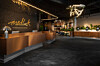 Modern hotellobby med reception, sittplatser, växter och skylten Medlock på väggen.