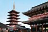 Femvåningspagod och traditionella tempelbyggnader i en japansk tempelmiljö under klarblå himmel.
