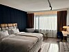 Tyylikäs hotellihuone, jossa on suuri sänky, työpiste ja valoisa ikkuna.