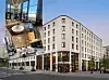 Collage med en ljus hotellbyggnad och interiörbilder från lobby, restaurang och lounge.