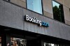 Booking.com-logotyp på fasaden till en modern kontorsbyggnad.