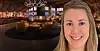 Leende kvinna framför en elegant restaurangmiljö med bar, sittgrupper och varm belysning.