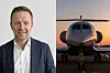 Porträtt av en man bredvid ett mindre affärsflygplan på en flygplats i kvällsljus.